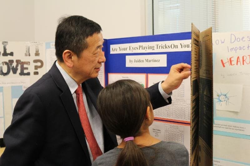 Dr. Li talking with one of his students at the county science-fair open house.