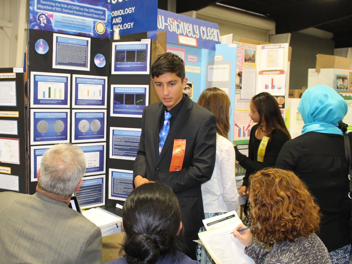 An Ardent Scholar presenting his project to judges at a science fair.
